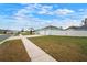 Side view of a light blue home showcasing the spacious lawn and white picket fence at 11248 Andy Dr, Riverview, FL 33569