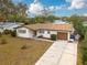 An aerial view of a single-story home with a large driveway and a well-maintained lawn at 121 Shirley Dr, Largo, FL 33770