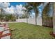 Green backyard with well-maintained lawn, palm trees, privacy fence, and sparkling pool, creating a serene retreat at 121 Shirley Dr, Largo, FL 33770