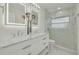 Bright bathroom featuring marble walk-in shower, dual vanity with illuminated mirrors and marble countertop at 121 Shirley Dr, Largo, FL 33770