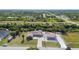 Expansive aerial view of a home with an additional storage building amid lush greenery and neighborhood at 12769 Foresman Blvd, Port Charlotte, FL 33981