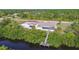 Aerial view of home with dock, waterfront access, screened lanai, separate garage/storage, and verdant surroundings at 12769 Foresman Blvd, Port Charlotte, FL 33981