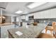 This kitchen features granite countertops, stainless steel appliances, and a view of the dining room at 12769 Foresman Blvd, Port Charlotte, FL 33981