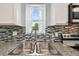 This kitchen features a stainless steel sink, granite countertops, and a view of the backyard at 12769 Foresman Blvd, Port Charlotte, FL 33981