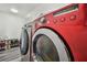 Close-up of front-load washer and dryer with various cycle options and a soda supply on the floor at 12769 Foresman Blvd, Port Charlotte, FL 33981