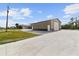 Exterior shot of a large outbuilding with a roll-up door and concrete driveway at 12769 Foresman Blvd, Port Charlotte, FL 33981