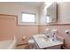 Retro bathroom with pink tiling, vanity, a tub, and a window at 12845 95Th N St, Largo, FL 33773