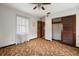 Bedroom with a ceiling fan, carpeted flooring, a window, closet, and a brown door at 12845 95Th N St, Largo, FL 33773