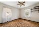 Bedroom with a ceiling fan, carpeted flooring, two windows, and minimal furniture at 12845 95Th N St, Largo, FL 33773