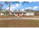 Well-maintained single-story home with red door and trim, plus a charming decorative front yard at 12845 95Th N St, Largo, FL 33773