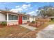 Charming single-story home boasts a vibrant red front door and a well-manicured front yard at 12845 95Th N St, Largo, FL 33773