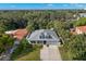 Charming home from an aerial view showcasing a grey roof, driveway, and beautiful tropical landscaping at 140 Miramar Ne Blvd, St Petersburg, FL 33704