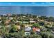 Scenic aerial shot of a beautiful home near bay waters, surrounded by lush trees and tropical landscaping at 140 Miramar Ne Blvd, St Petersburg, FL 33704