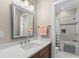 Well-lit bathroom featuring a vanity with a white countertop, a framed mirror, and access to the shower at 140 Miramar Ne Blvd, St Petersburg, FL 33704