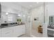 Modern bathroom with a glass shower, marble tile, and a sleek vanity with a dark countertop and white cabinets at 140 Miramar Ne Blvd, St Petersburg, FL 33704