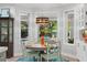 Bright breakfast nook with a round table, chairs, view of the outdoor pool and tropical foliage at 140 Miramar Ne Blvd, St Petersburg, FL 33704