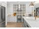 Kitchen featuring white cabinetry, stainless steel appliances, designer tile backsplash, and a gold kitchen faucet at 140 Miramar Ne Blvd, St Petersburg, FL 33704