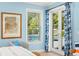 Bright main bedroom with a view of the pool through French doors and stylish blue curtains at 140 Miramar Ne Blvd, St Petersburg, FL 33704