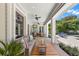 Outdoor living area with a covered porch, ceiling fans, and a view of the landscaped backyard and pool at 140 Miramar Ne Blvd, St Petersburg, FL 33704