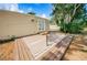 Backyard wooden deck with sunny view of trees and minimal landscaping at 185 New England Ave # 33, Palm Harbor, FL 34684