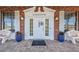 Charming front entrance with double doors, flanked by benches and potted plants at 185 New England Ave # 33, Palm Harbor, FL 34684