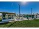 Outdoor shuffleboard court featuring green turf, shelter, and lush landscaping, ideal for leisurely recreation at 185 New England Ave # 33, Palm Harbor, FL 34684