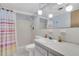 Bathroom featuring a shower, sink, toilet, and decorative fixtures, illuminated by globe-shaped lights at 1868 Shore S Dr # 602, South Pasadena, FL 33707