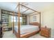 Bedroom with a four-poster bed, built in bookcase, ceiling fan, and natural light from the window at 1868 Shore S Dr # 602, South Pasadena, FL 33707