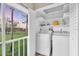 Convenient laundry room with washer, dryer, shelving, and a view of the outdoors at 204 Mary Dr, Oldsmar, FL 34677