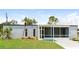 View of the home's exterior, featuring a screened-in porch and well-maintained lawn at 2054 Pennsylvania Ave, Englewood, FL 34224