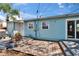 Charming light blue home showcasing a brick patio area, ideal for outdoor seating and enjoyment of the backyard at 2661 45Th S St, Gulfport, FL 33711