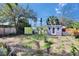 Spacious backyard with green and purple storage sheds surrounded by greenery, offering functionality and charm at 2661 45Th S St, Gulfport, FL 33711