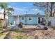 Cozy light blue home featuring a brick patio and grassy yard, perfect for outdoor entertaining and relaxation at 2661 45Th S St, Gulfport, FL 33711