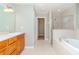 Bathroom featuring a soaking tub, walk-in shower, and wood vanity with sink at 3206 Duchess Ct, Plant City, FL 33565