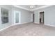 Large carpeted main bedroom features tray ceiling and natural light from windows and glass door at 3206 Duchess Ct, Plant City, FL 33565