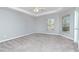 Spacious bedroom with neutral carpet, tray ceiling, and natural light from windows and glass door at 3206 Duchess Ct, Plant City, FL 33565