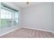 Neutral bedroom featuring carpet and a large window overlooking the yard at 3206 Duchess Ct, Plant City, FL 33565