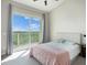 Cozy bedroom with a balcony overlooking green treetops; natural light fills the room at 3266 Mangrove Point Dr, Ruskin, FL 33570