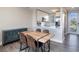 Bright dining area featuring a wood table, seating for four, modern blue buffet, and a view of the kitchen at 3266 Mangrove Point Dr, Ruskin, FL 33570