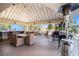 Outdoor patio area with tables, chairs, ceiling fans, an ocean view, and lush landscaping at 3266 Mangrove Point Dr, Ruskin, FL 33570