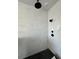 Modern shower with white marble style tile, black fixtures, and black tile floor at 3404 S Omar Ave, Tampa, FL 33629