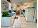 Well-lit kitchen featuring white appliances, countertops, and white tile floors at 3745 100Th N Pl # 3745, Pinellas Park, FL 33782