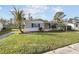 Charming single-story home with a well-maintained lawn, a bright yellow door, and mature landscaping at 3934 Moog Rd, Holiday, FL 34691