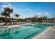 Pool and patio area featuring lounge chairs, sun umbrellas, and lush palm trees at 9727 Minnow Ray Dr, Land O Lakes, FL 34638