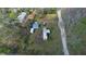 Aerial view of a single-story home with multiple outbuildings on a spacious lot with mature trees at 10519 Shalimar St, New Port Richey, FL 34654