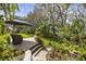 Charming backyard seating area under an umbrella features lush landscaping and mature trees at 108 Rosana Dr, Brandon, FL 33511