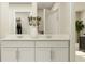 Bright bathroom featuring double sinks, white cabinets, quartz countertops, and a view of the closet at 12718 Crystal Jade Way, Parrish, FL 34219