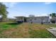 Large backyard with covered seating area and a mix of grass and gravel at 1489 77Th N Ave, St Petersburg, FL 33702