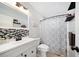 Updated bathroom with black and white tile, new vanity and shower with patterned curtain at 1489 77Th N Ave, St Petersburg, FL 33702