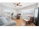 This bedroom has light hardwood flooring and a ceiling fan in addition to a sitting area and work desk at 1489 77Th N Ave, St Petersburg, FL 33702